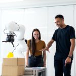 Dois engenheiros colaboram na avaliação de um protótipo robótico em um laboratório moderno.